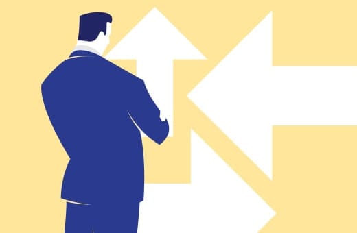 Businessman in a blue suit stands with his back to the viewer as large white arrows point in multiple directions on a yellow background, signaling a choice of path.